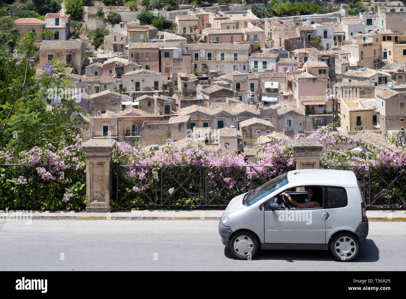 Blanco compacto pequeño coche de ciudad en la colina de la Ciudad Modica Alta, famosa por su arquitectura barroca, Sudeste de Sicilia, Italia Foto de stock