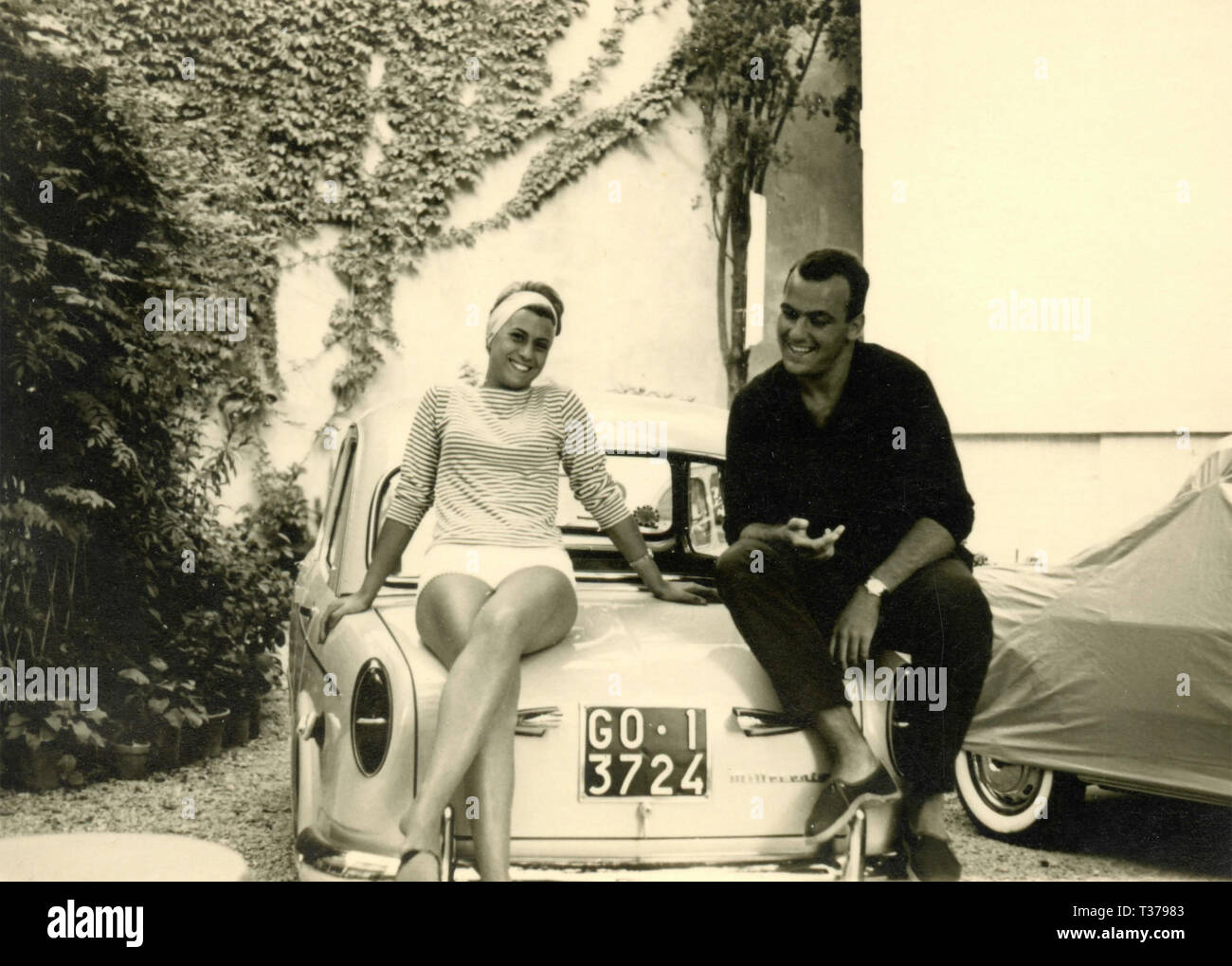 Chico y chica sentada en el coche, Italia 1960 Foto de stock