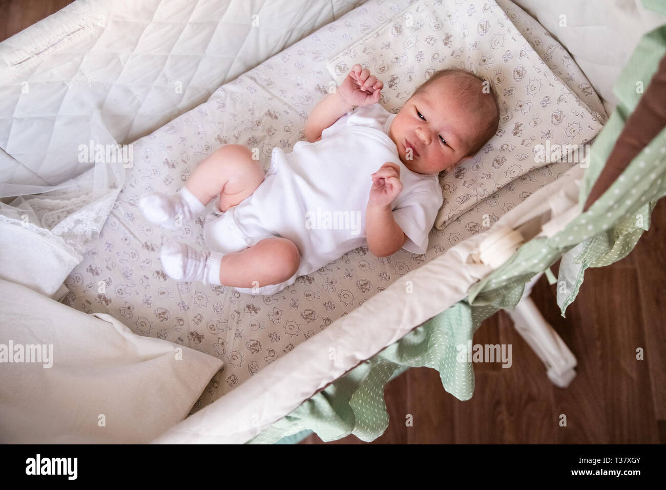 Bebé recién nacido niño en cama. nacido en blanco luz bodykit acostado en la cuna. Los niños duermen. Ropa de cama para Bebé, una siesta en la cama. Littl