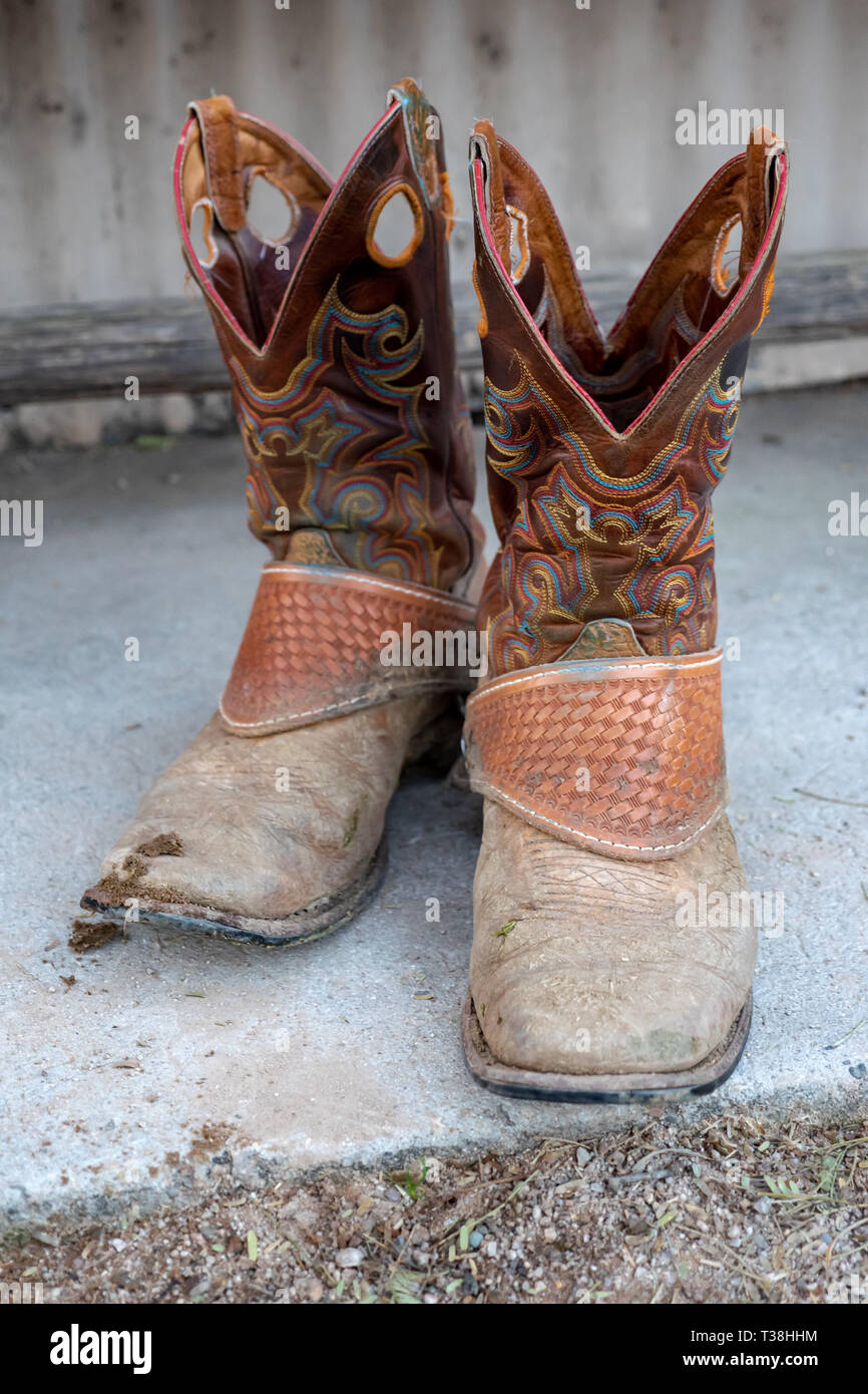 Gusano botas de vaquero en el porche reflejan el trabajo duro con la ética  del cowboy americano Fotografía de stock - Alamy