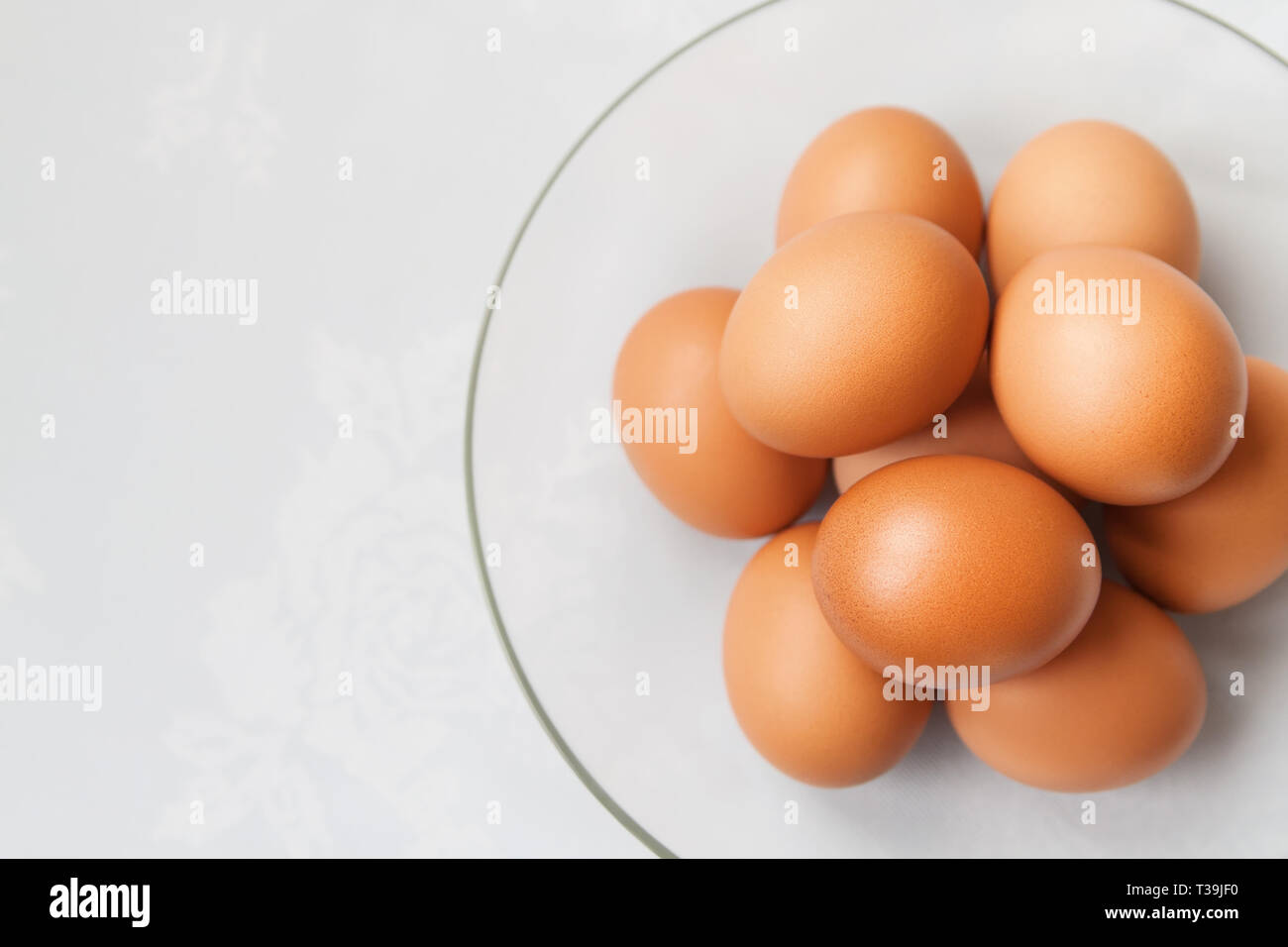 El plato de la gallina de los huevos de color marrón fresca sobre el mantel de lino y el espacio de copia Foto de stock