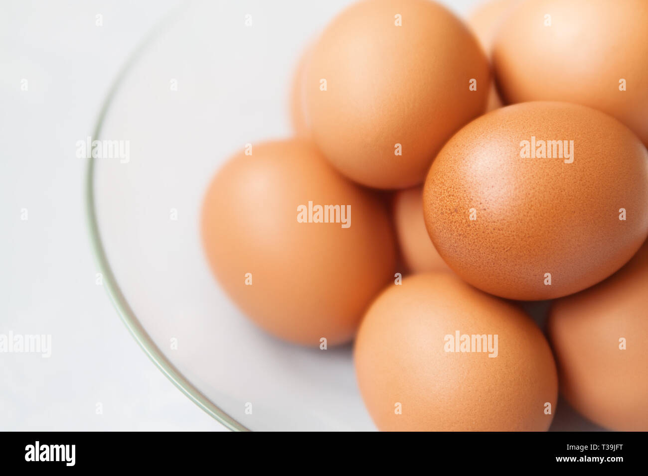 Los huevos de gallina marrón fresco en la placa de vidrio cerrar Foto de stock