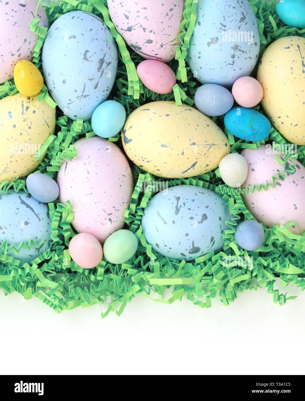 Colección de coloridos huevos de Pascua y dulces de fondo con espacios en blanco. Foto de stock