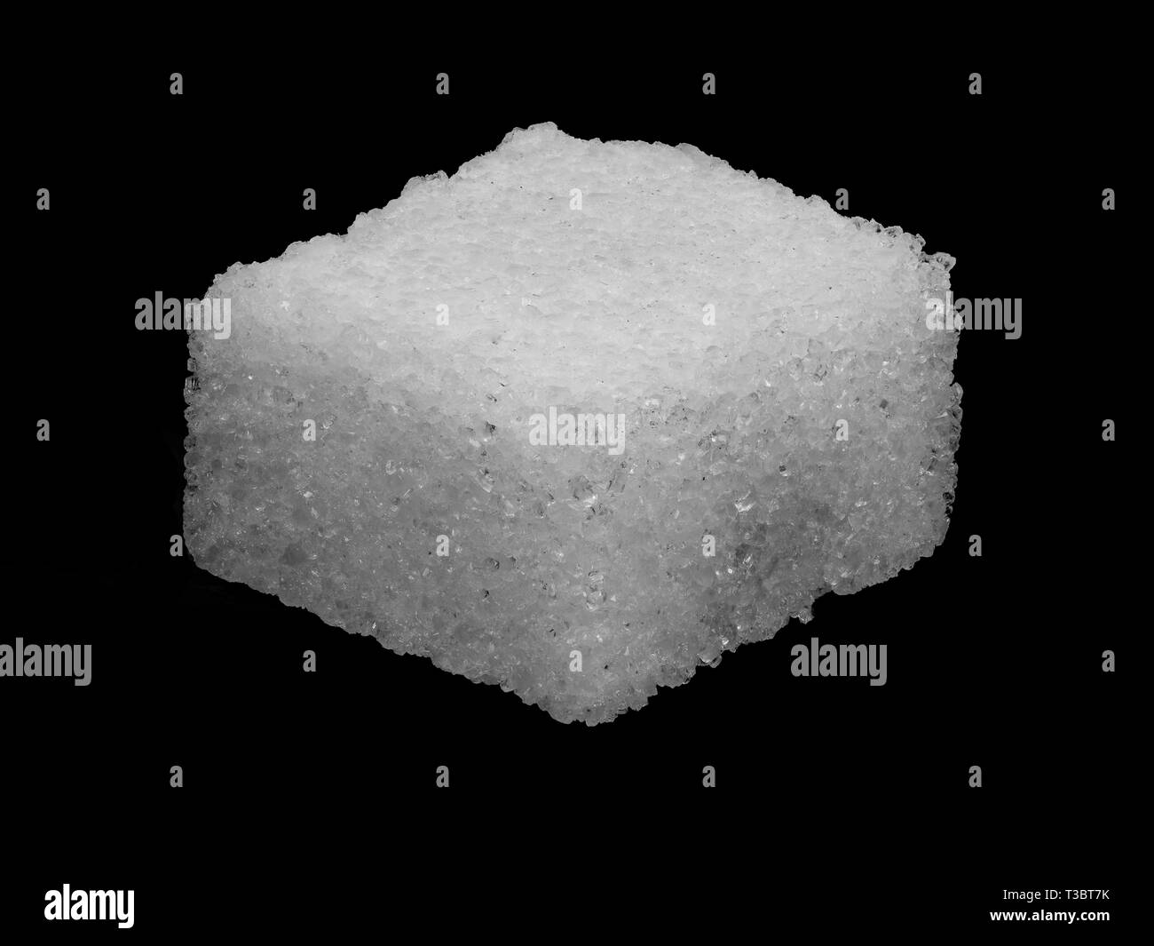 Imagen macro de un cubo de azúcar aislado en un fondo negro Foto de stock