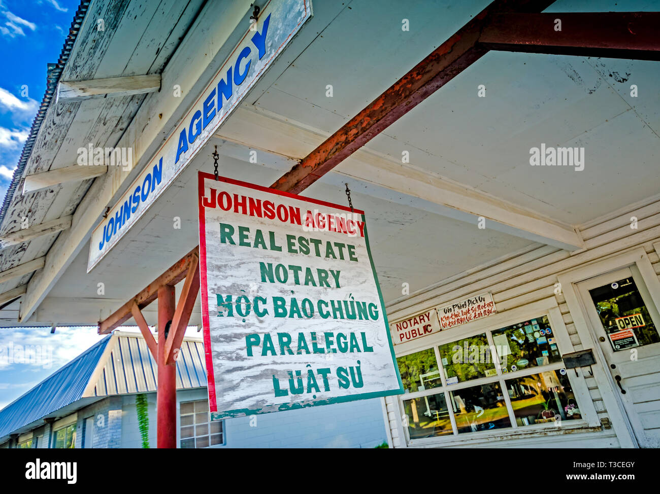 Letreros en inglés y vietnamita publicidad inmobiliaria y notario público servicios ofrecidos por Agencia Johnson, 15 de agosto de 2015, en Bayou La Batre, Alabama. Foto de stock