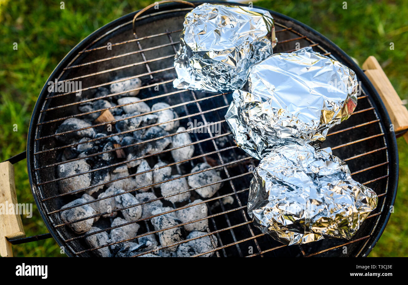 Baby Back Ribs Crown asado en barbacoa Barbacoa Grill hervidor de agua.  Hecho en casa costillas de cerdo a la parrilla con bajo y lento método. Las  costillas envueltas en papel de