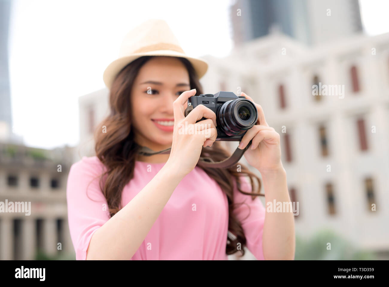 Estilo de vida al aire libre en verano sonriente retrato de mujer bastante joven divirtiéndose en la ciudad de Asia con cámara de fotos de viajes del fotógrafo Foto de stock