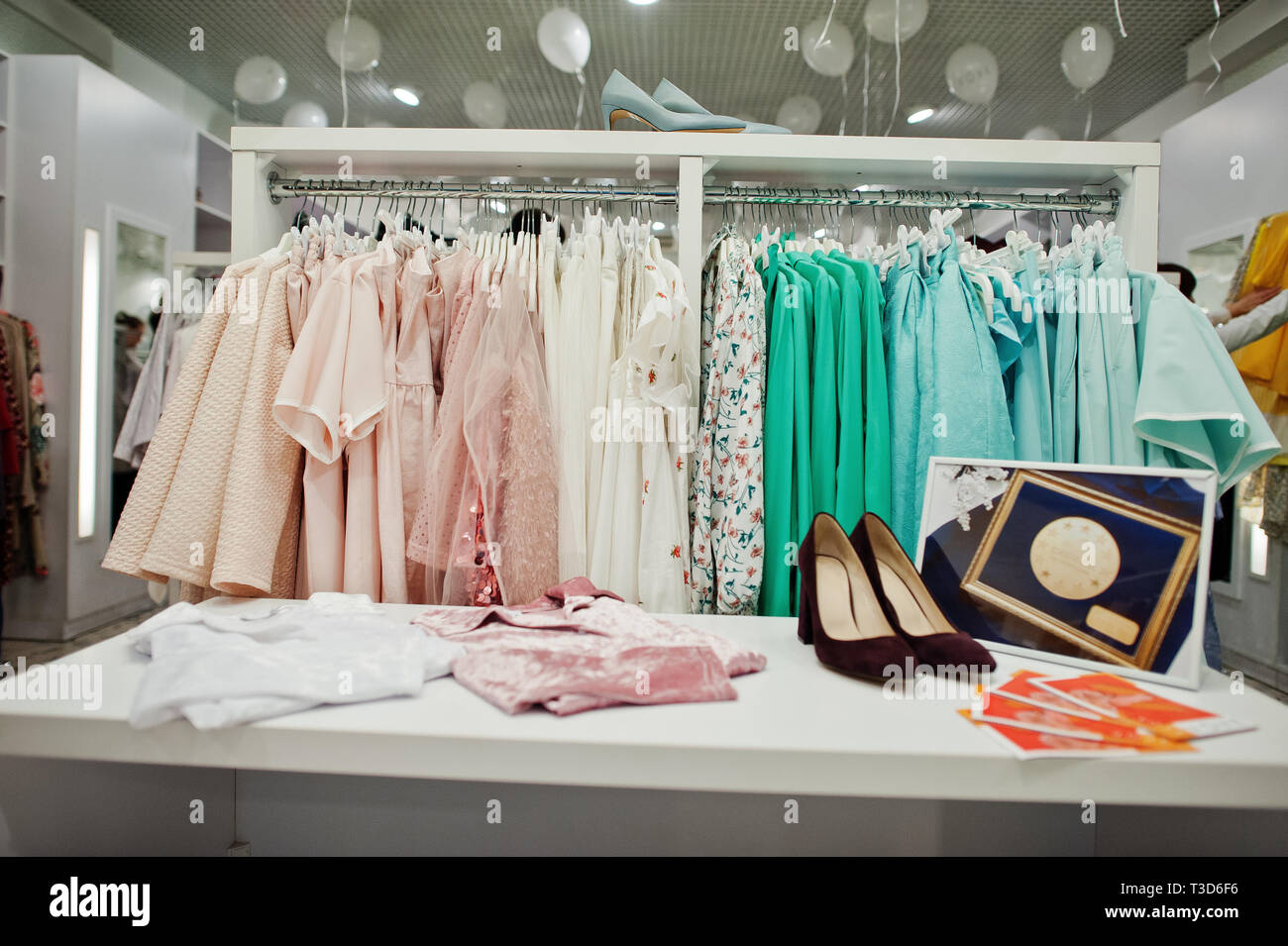 Colorido juego de ropa femenina en los racks con los zapatos en la tienda  de ropa boutique flamante y moderno. Colecciones vestidos primavera verano  Fotografía de stock - Alamy