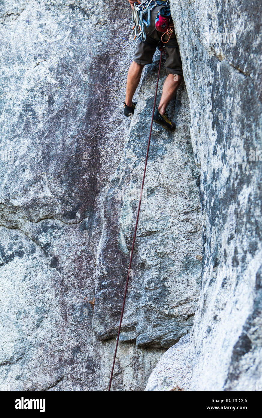 Un hombre escalador ejecuta (subiendo un largo camino sin proteger la posible caída) en el pequeño fume Bluffs área de escalada, Squamish, BC. Foto de stock