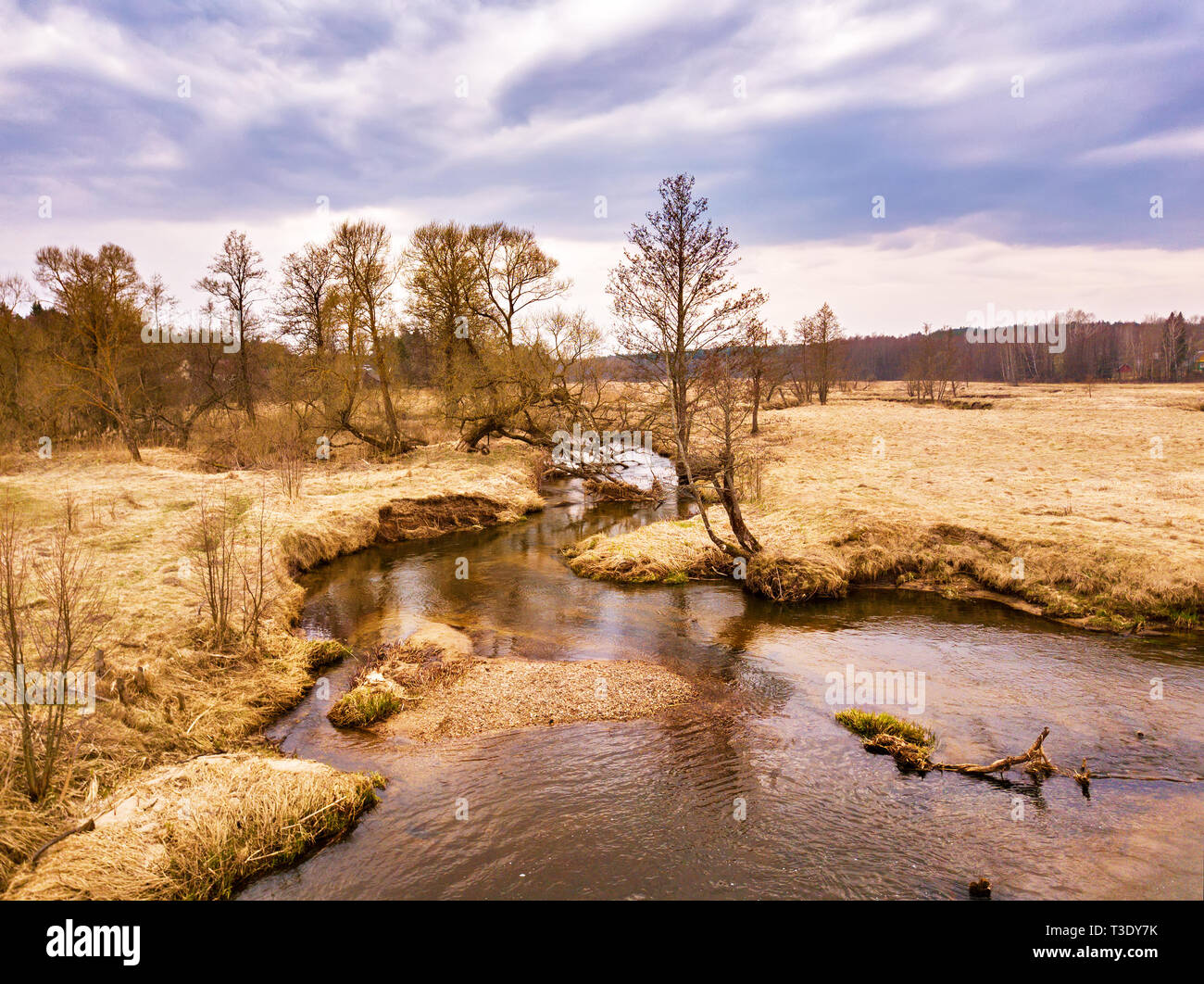Paisaje rural en abril. Pequeño Río Sula a principios de la primavera. Vista aérea de Brook dobleces en un medow. Bielorrusia Foto de stock