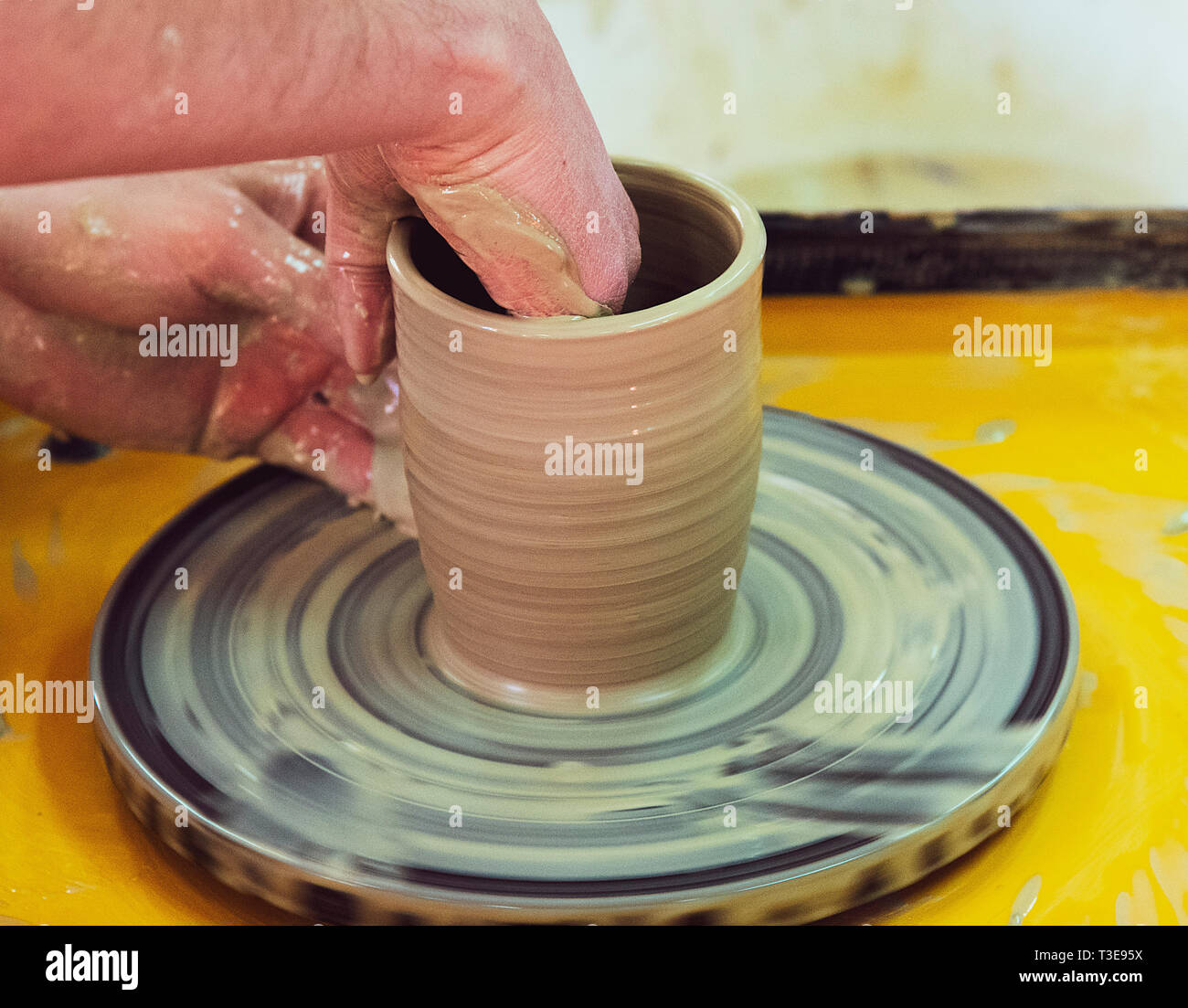 Clase magistral sobre cómo hacer una vasija de cerámica con un torno de  alfarero. La cerámica está girando alrededor de su eje Fotografía de stock  - Alamy