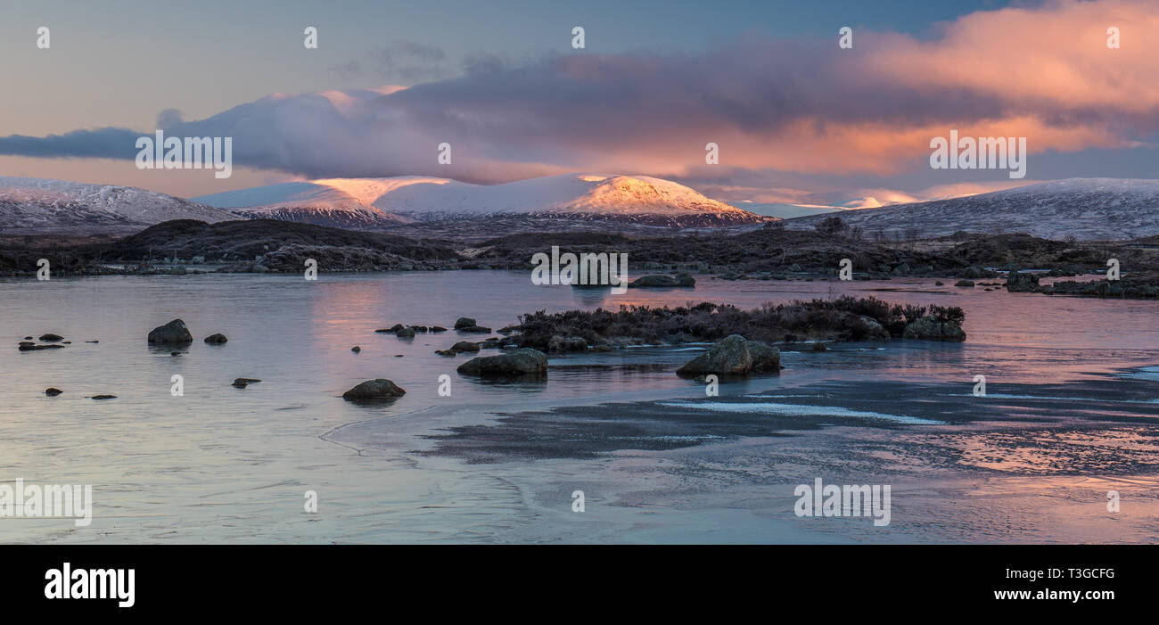 Amanecer sobre un congelado Lochan na h-achlaise sobre Rannoch Moor, cerca de la entrada a Glencoe en las Highlands escocesas Foto de stock