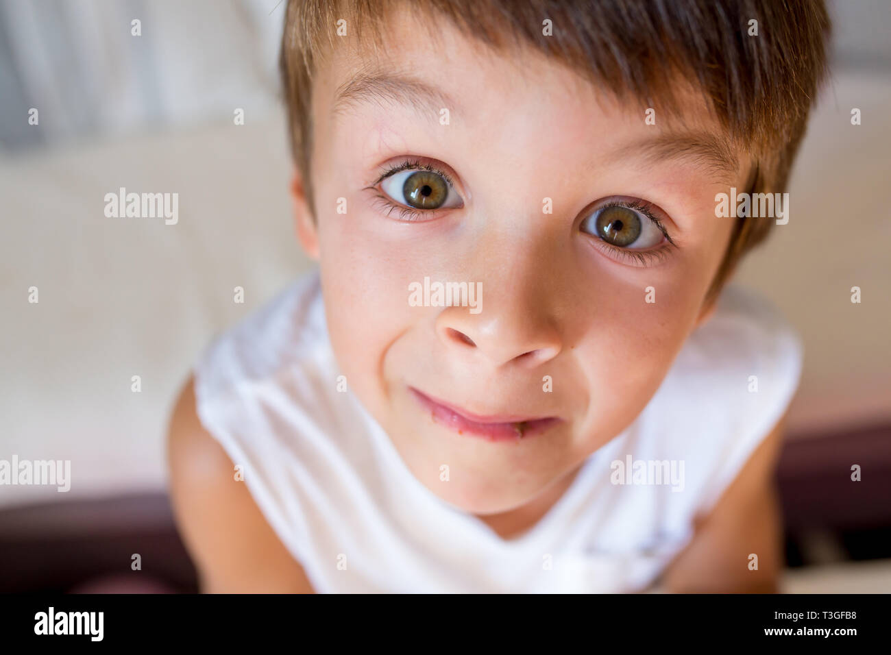 Dulce niño cumpleaños comiendo gofre belga con fresas, frambuesas y chocolate en casa Foto de stock