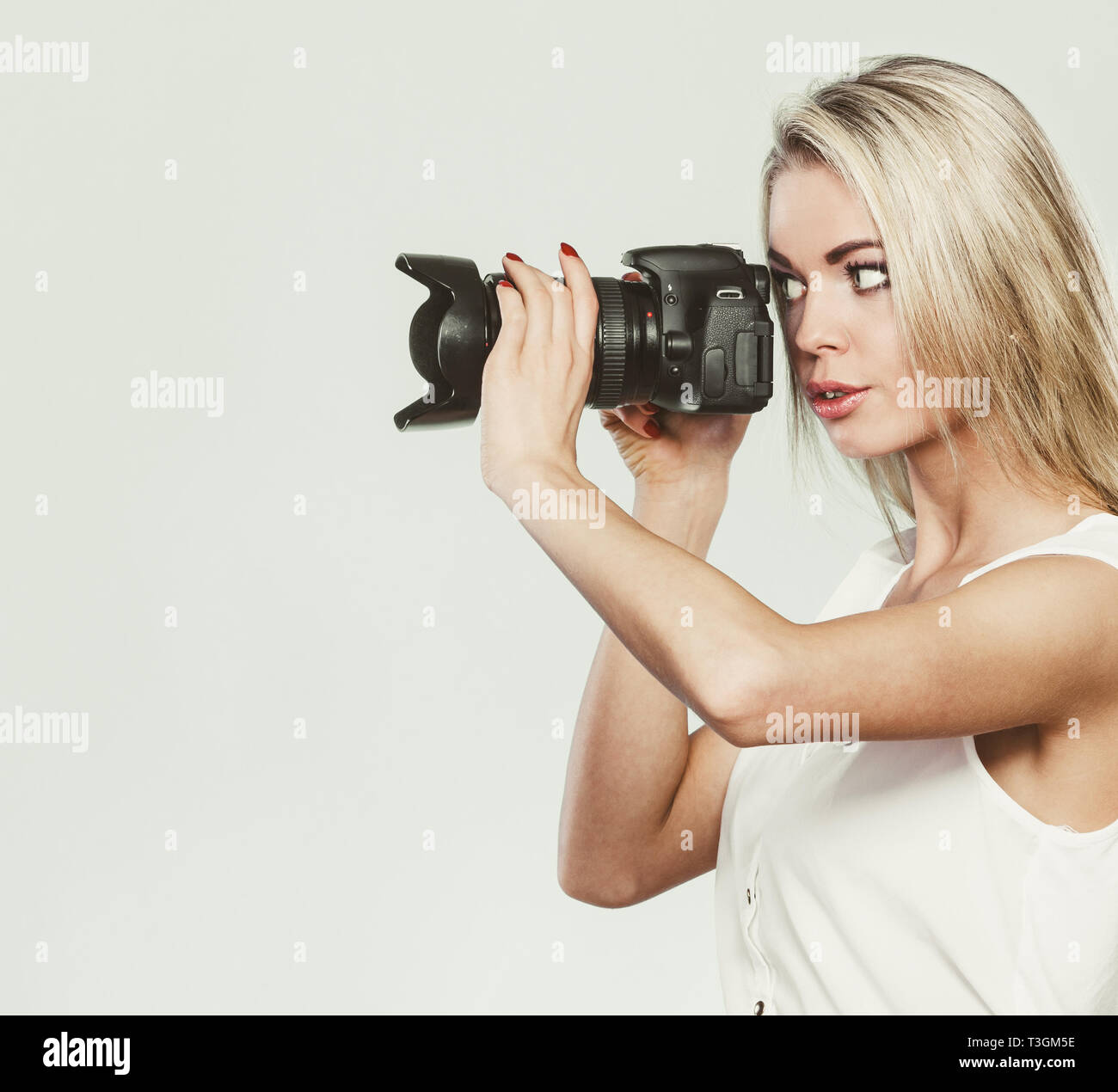 Fotógrafo chica disparar imágenes. Atractiva mujer rubia tomando fotos con  la cámara. Foto filtrada Fotografía de stock - Alamy