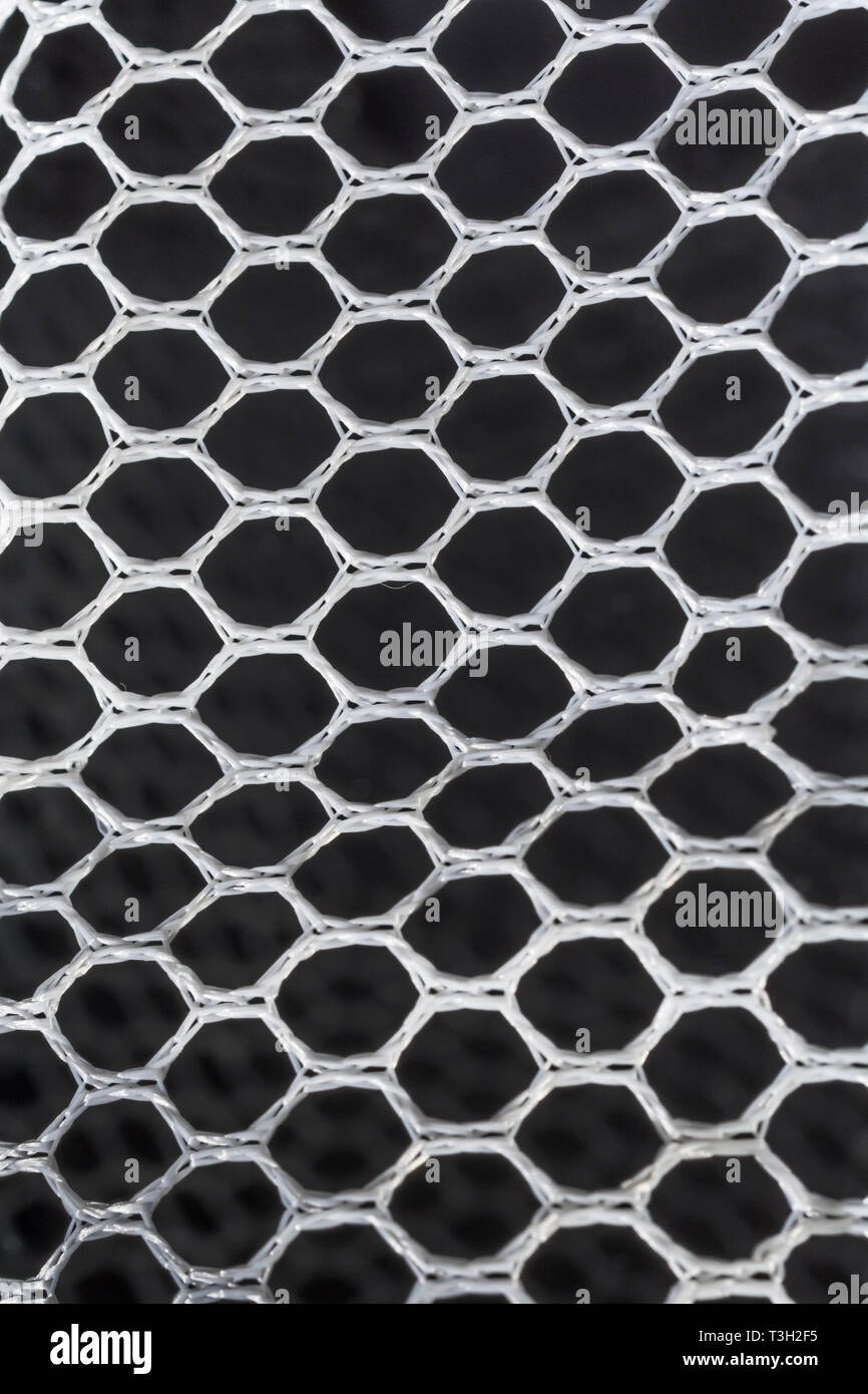 Macro-fotografía de fina malla tejida en poliéster blanco / neteo con fondo negro. Orificios de 4 mm de diámetro aproximadamente. Foto de stock