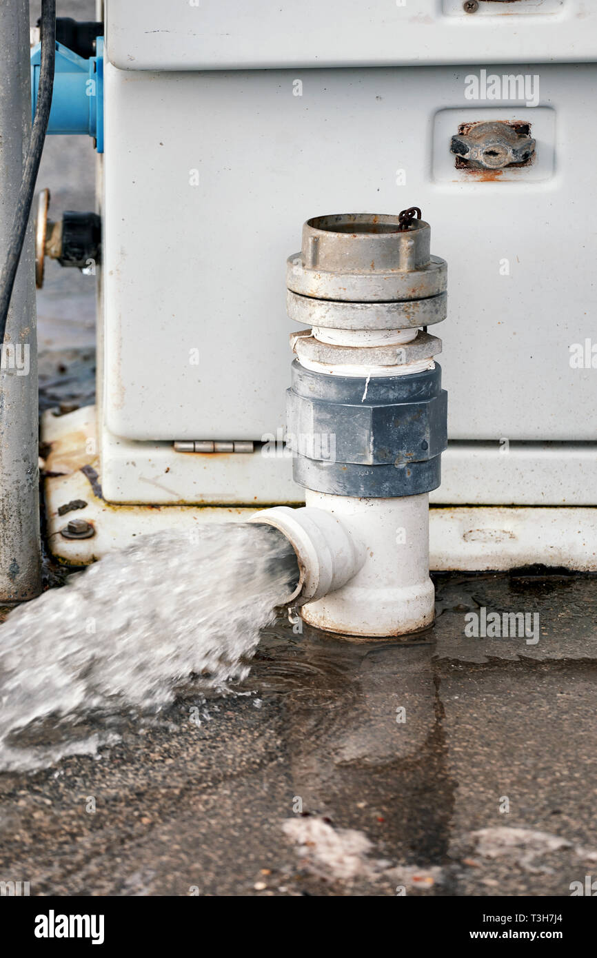 Las aguas residuales procedentes de un tubo PCV está goteando en el piso de  la calle Fotografía de stock - Alamy