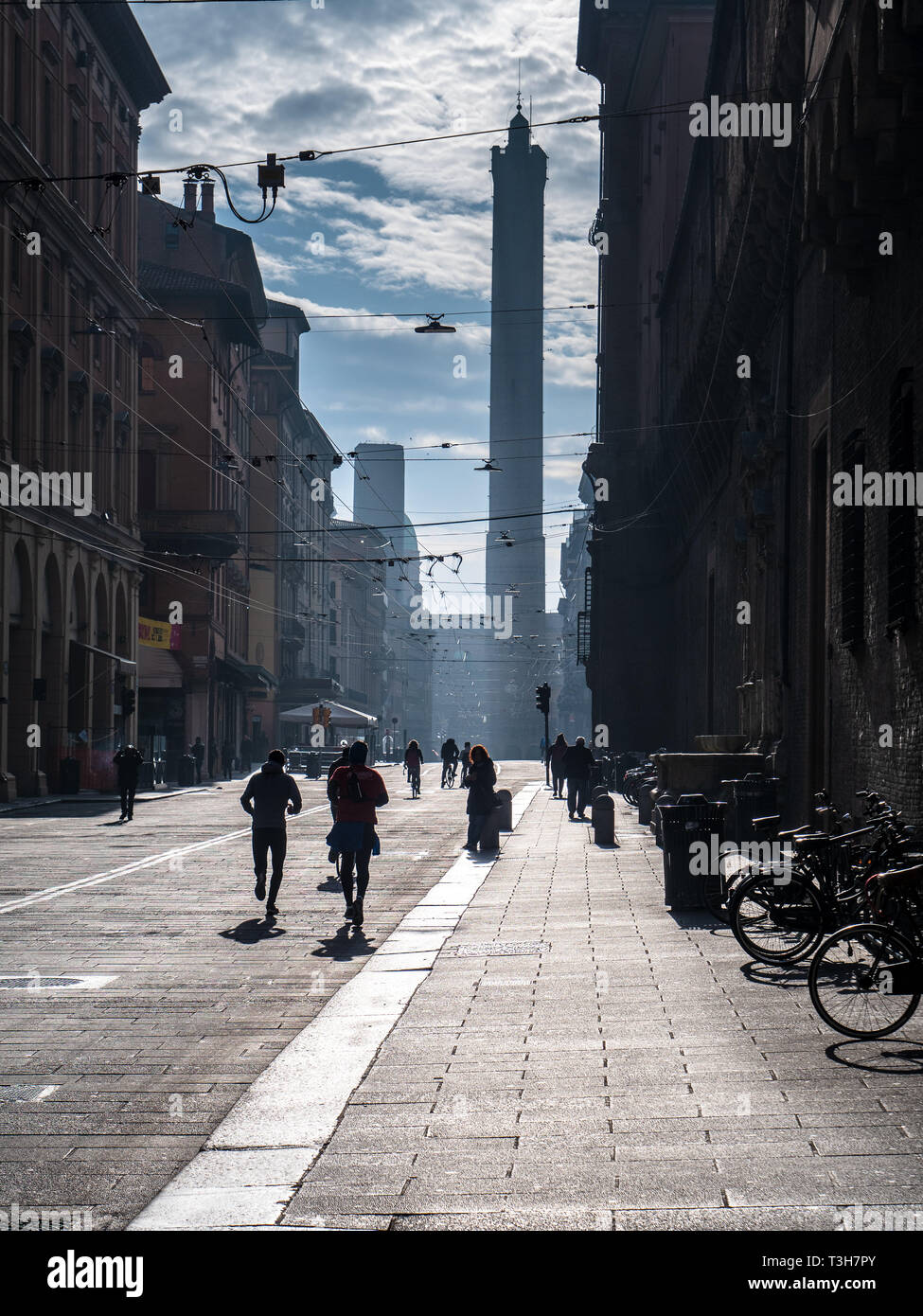 Domingo por la mañana, los corredores en el centro de la ciudad de Bolonia con las Torres Gemelas, La Torre Garisenda y la Torre Asinelli en la distancia. Foto de stock