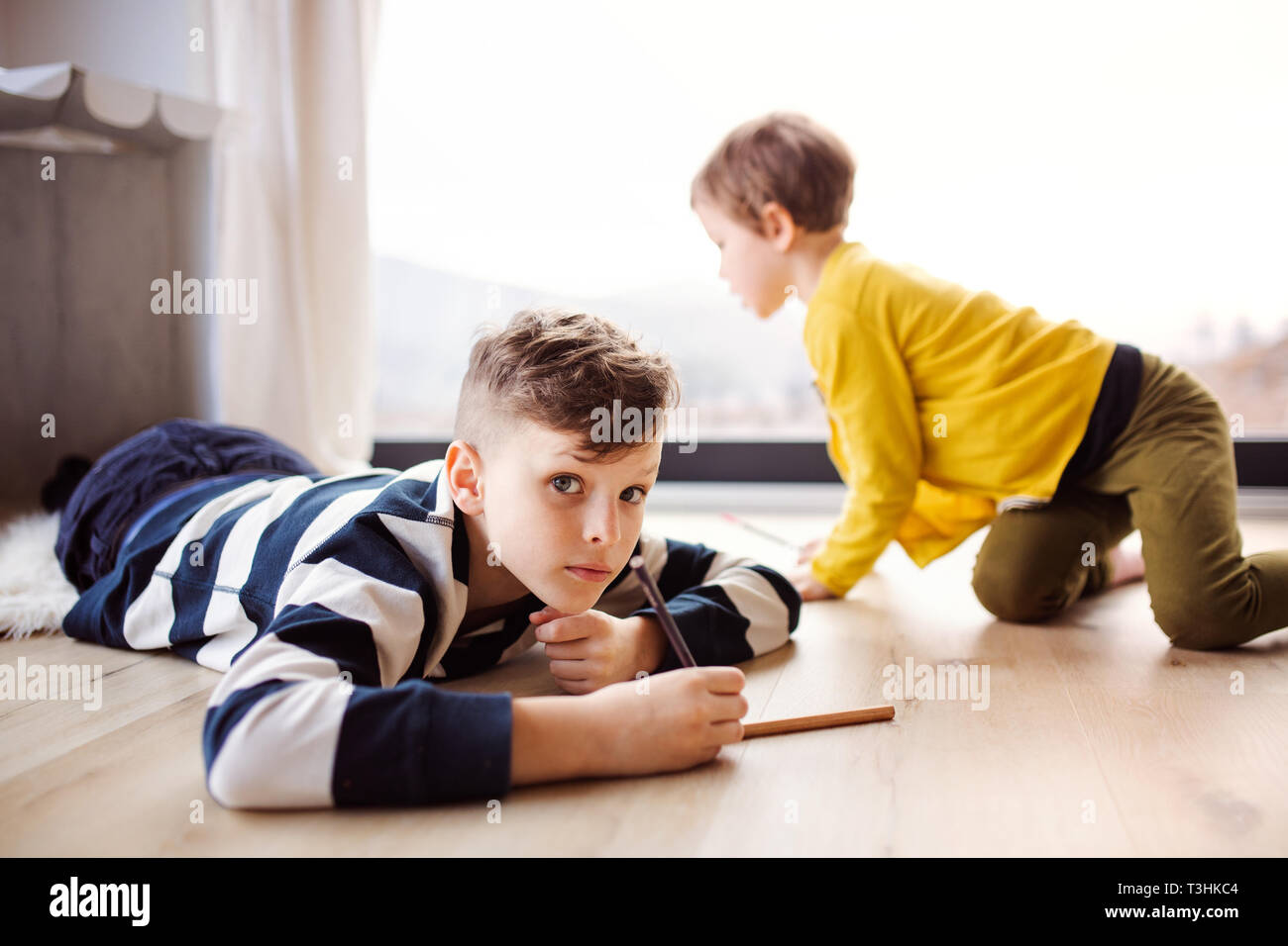 Dos niños felices jugando en casa, el dibujo. Foto de stock
