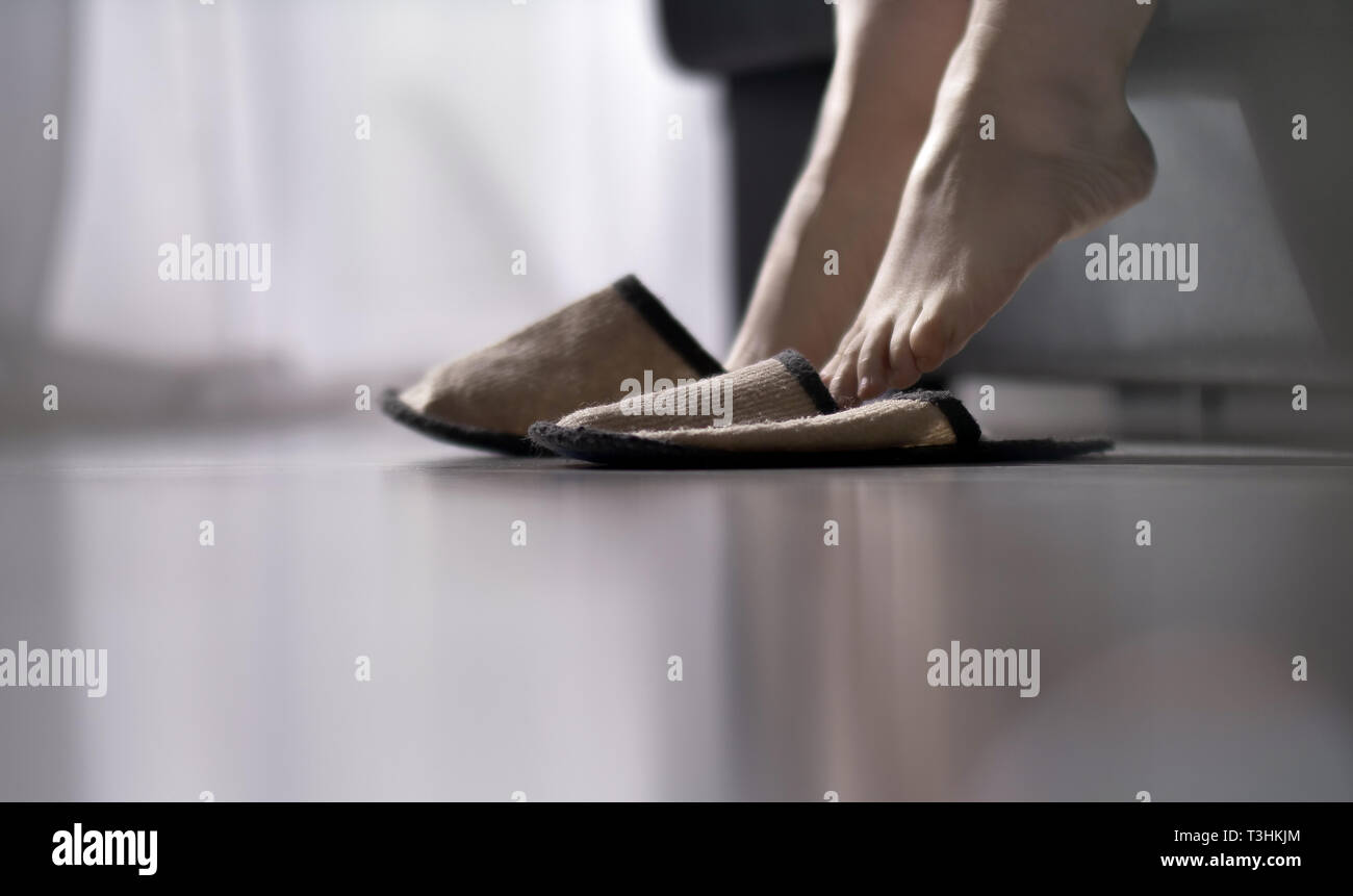 Mujer vistiendo zapatillas de levantarse de la cama Fotografía de stock -  Alamy
