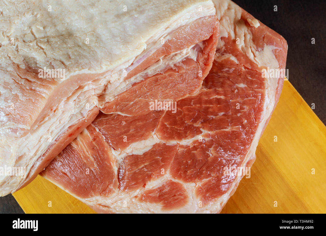 La carne de cerdo cruda sobre una tabla de madera Foto de stock
