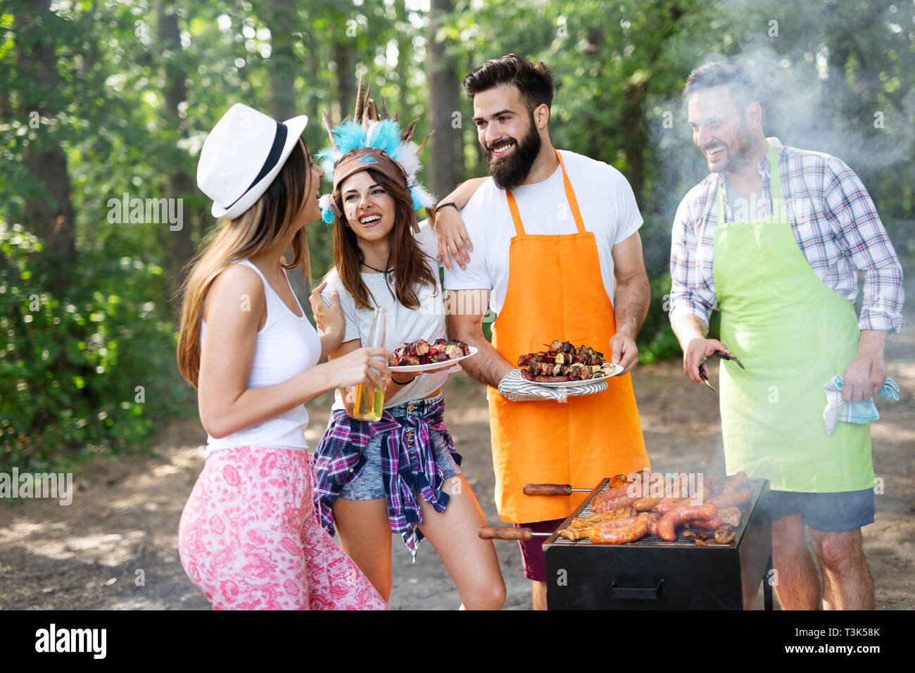 Feliz amigos camping y tener una barbacoa en la naturaleza Foto de stock