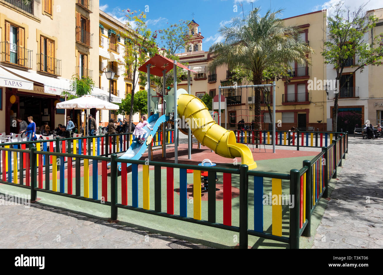 Chica subiendo una diapositiva en un patio en Sevilla Foto de stock