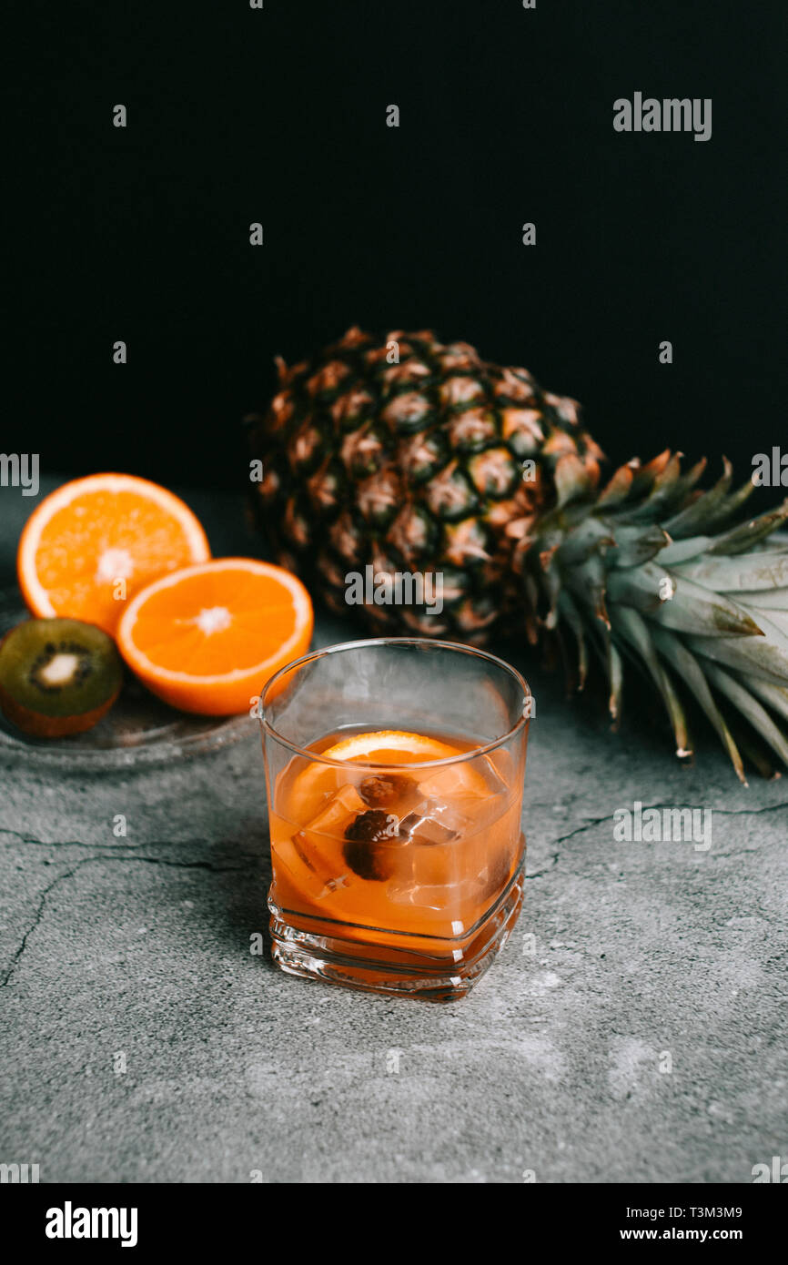Cóctel de whisky o vodka con naranja, piña y frambuesa con fruta como