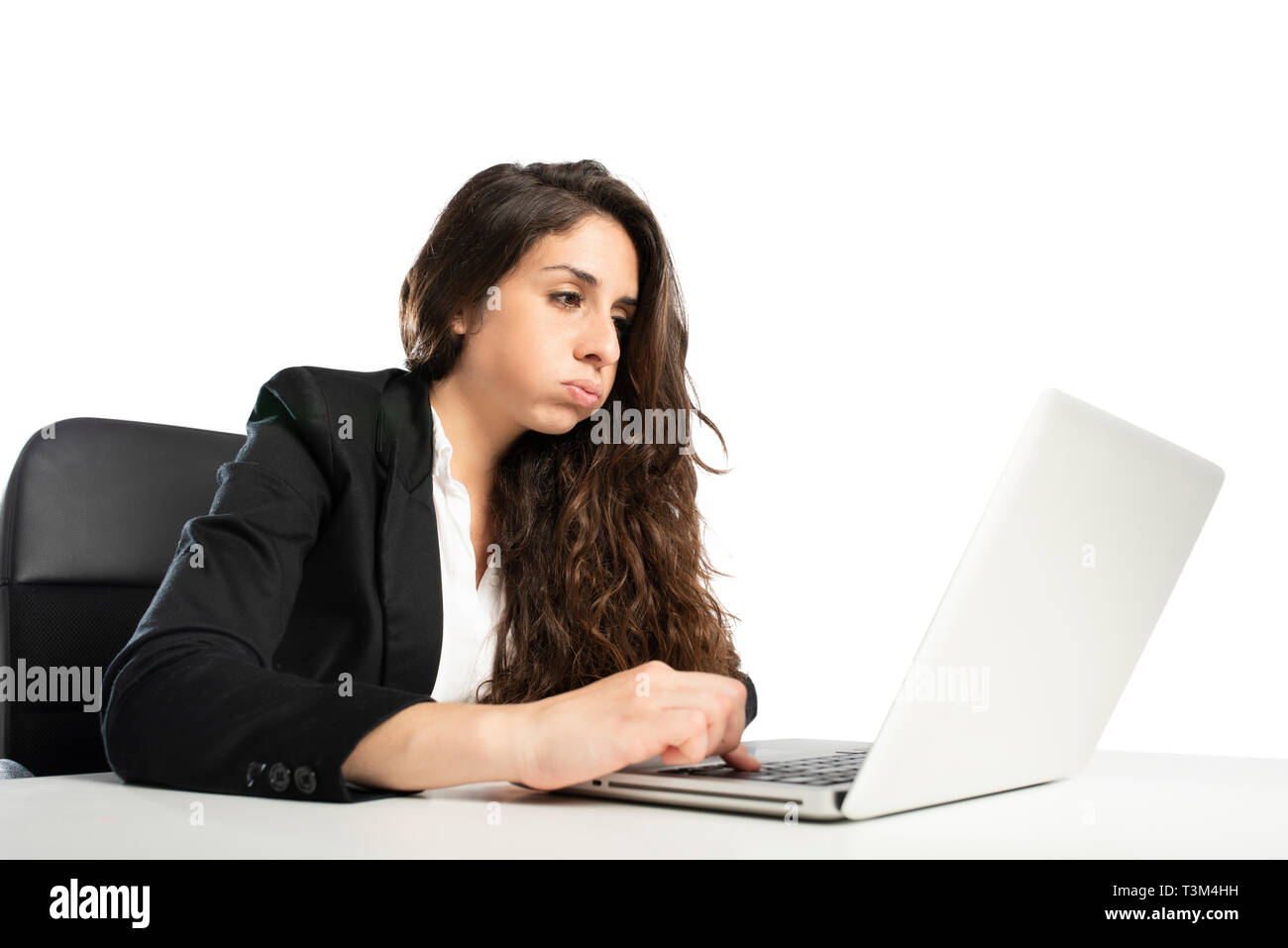 Mujer snorts aburridos en la oficina mientras trabajaba en el portátil. Foto de stock