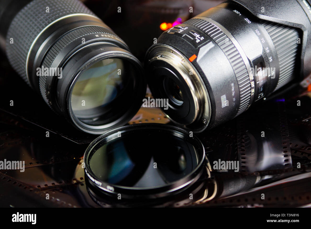 Cerca de dos lentes de cámara con filtro circular aislado de tiras de película negativas Foto de stock