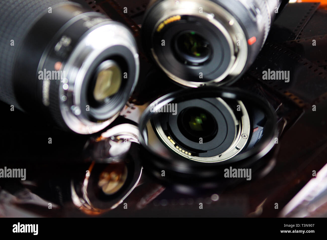 Cerca de dos lentes de cámara con filtro circular aislado de tiras de película negativas Foto de stock