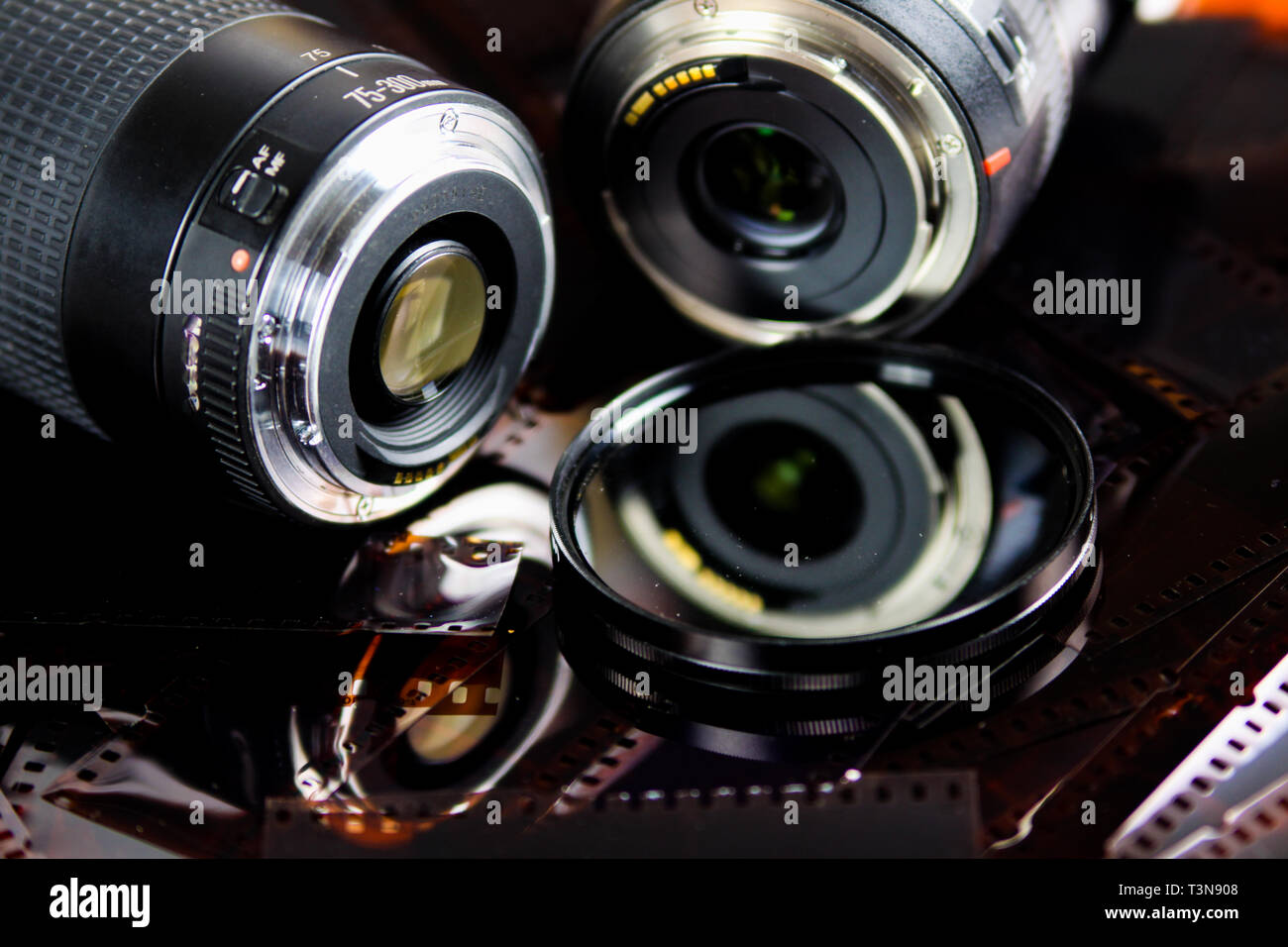 Cerca de dos lentes de cámara con filtro circular aislado de tiras de película negativas Foto de stock