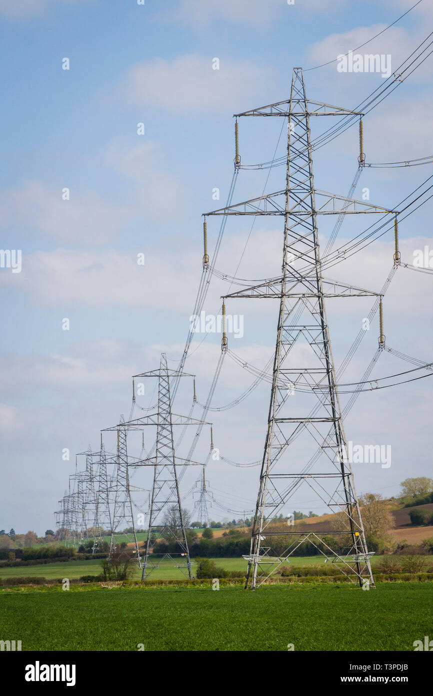 Una línea de torres eléctricas de marzo a través de la campiña inglesa al sur de Oxford Foto de stock