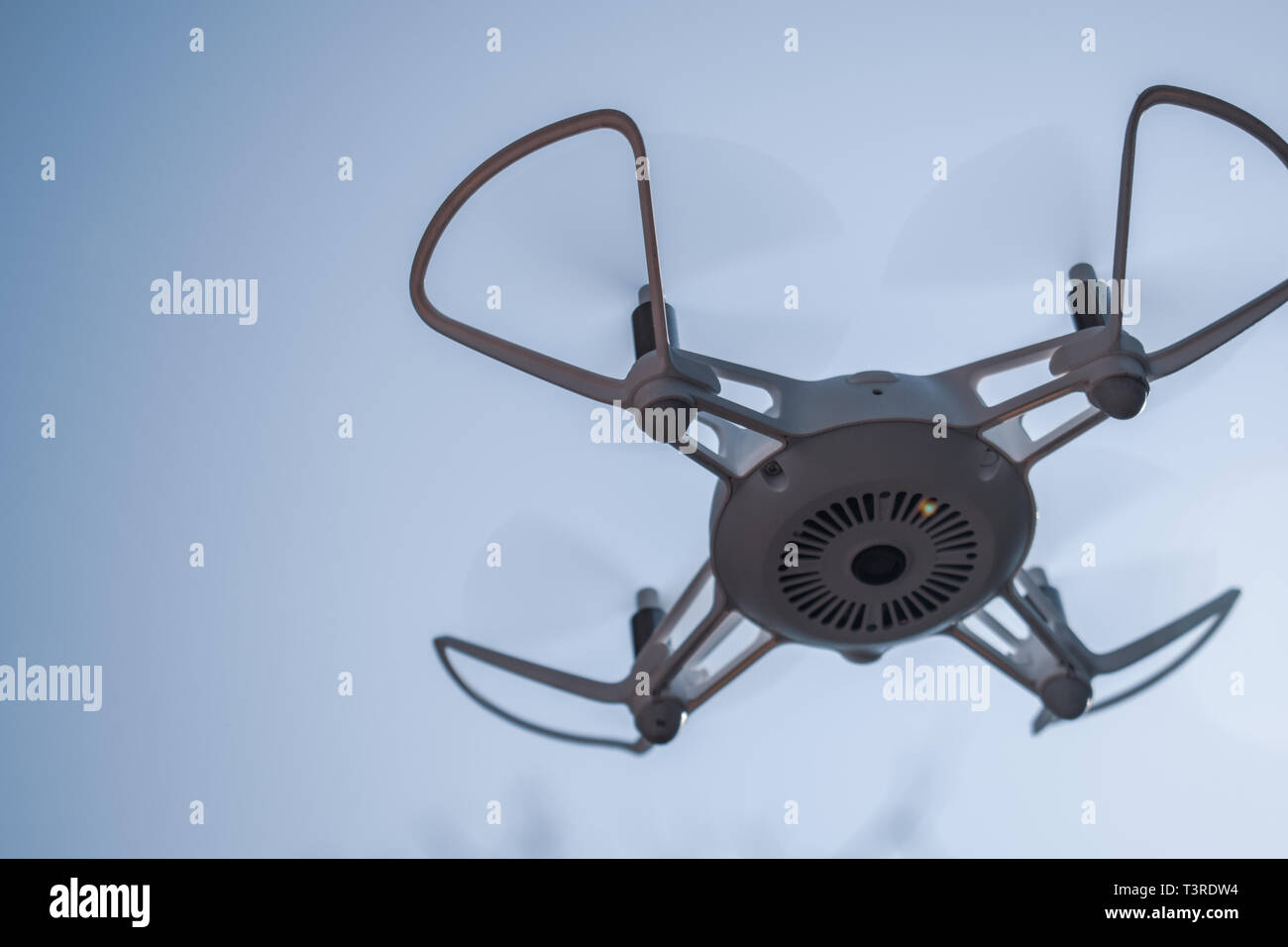 Drone Quadcopter flotando en un cielo azul Foto de stock