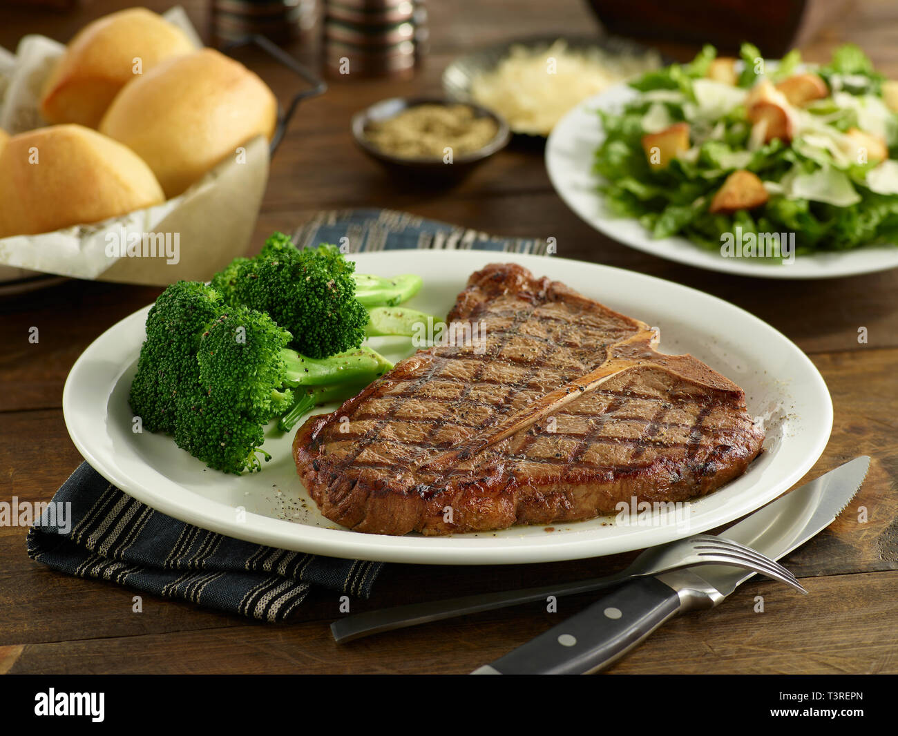 Porterhouse Steak con brócoli, ensalada y cena rollos Foto de stock
