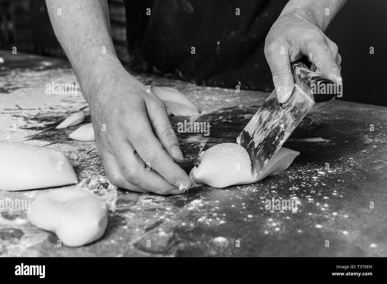 Manos de panadero porcionar la masa cruda con rasqueta Fotografía de stock  - Alamy