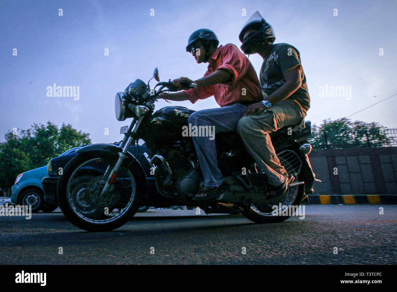 Un motociclista y su pasajero en una calle concurrida en New Dehli. El fabricante indio de coches Tata tiene un coche barato en el oleoducto. Para 2008 el coche que cuesta 100,000 rupías llegará al mercado, haciendo los automóviles asequibles para millones de indios. Los guardaparques en autobuses abarrotados ahora pueden permitirse coches con aire acondicionado Foto de stock