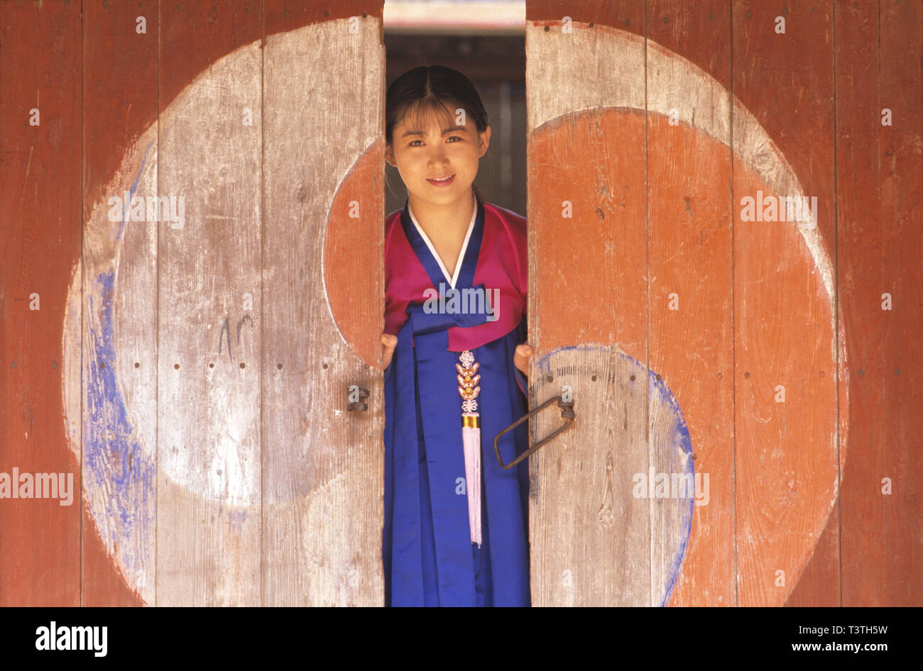 Corea del Sur. La ciudad de Seúl. Mujer joven con ropas tradicionales en busca de puertas de entrada del templo. Foto de stock