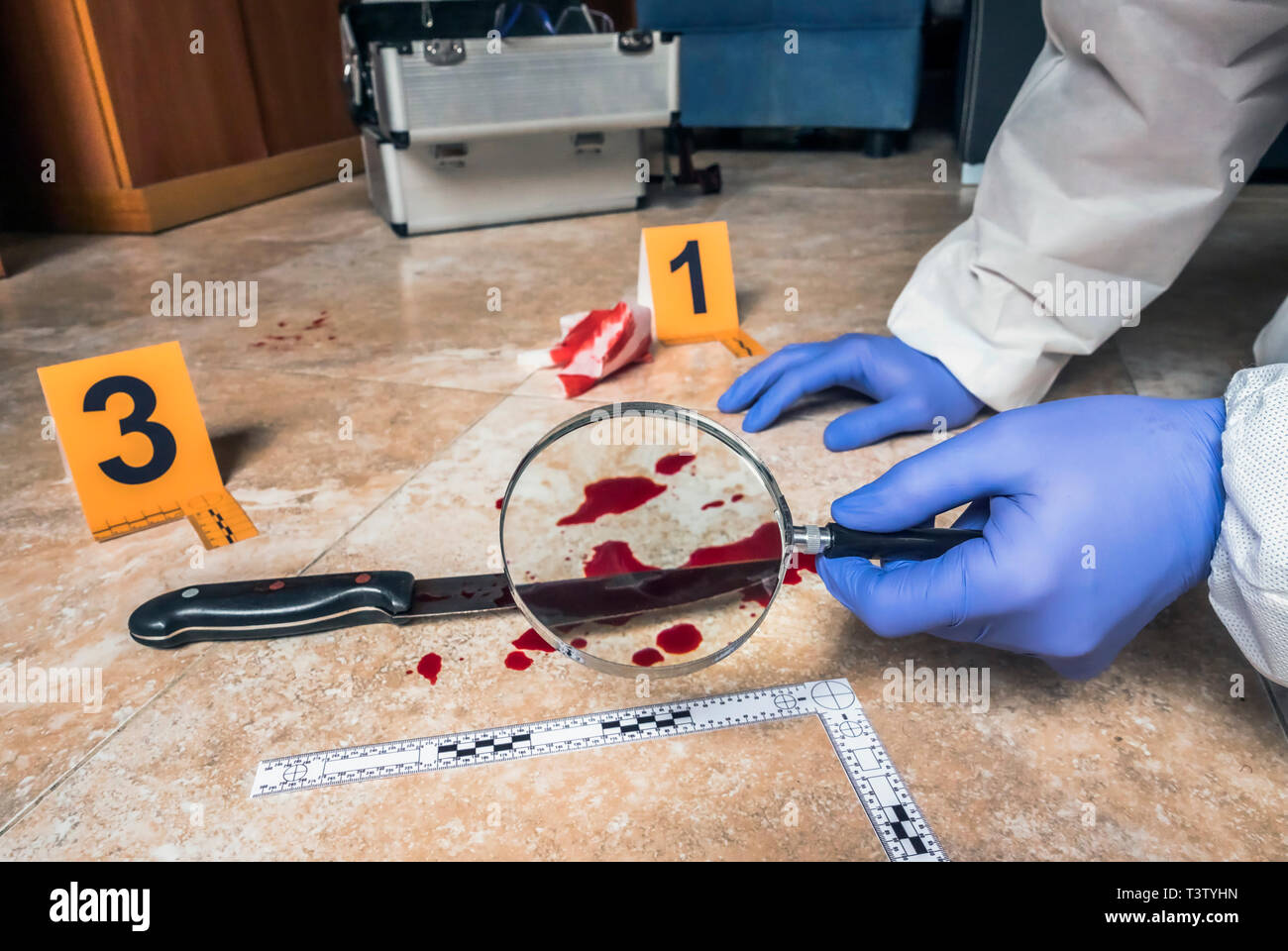 La policía de expertos examinar con lupa un cuchillo con sangre en la escena de un crimen, imagen conceptual Foto de stock