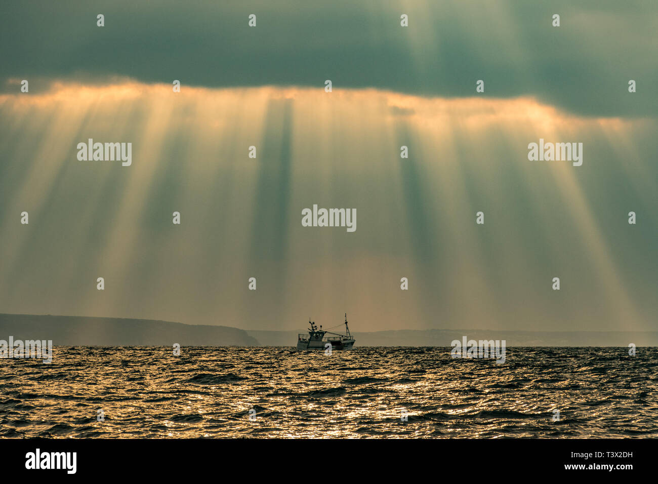 Mousehole, Cornualles, en el Reino Unido. 12 abr, 2019. El clima del Reino Unido. El sol hecho breve aparición aunque las nubes esta mañana, llevando algunas spectular crespicular rayos sobre el mar en Mounts Bay Credit: Simon Maycock/Alamy Live News Foto de stock