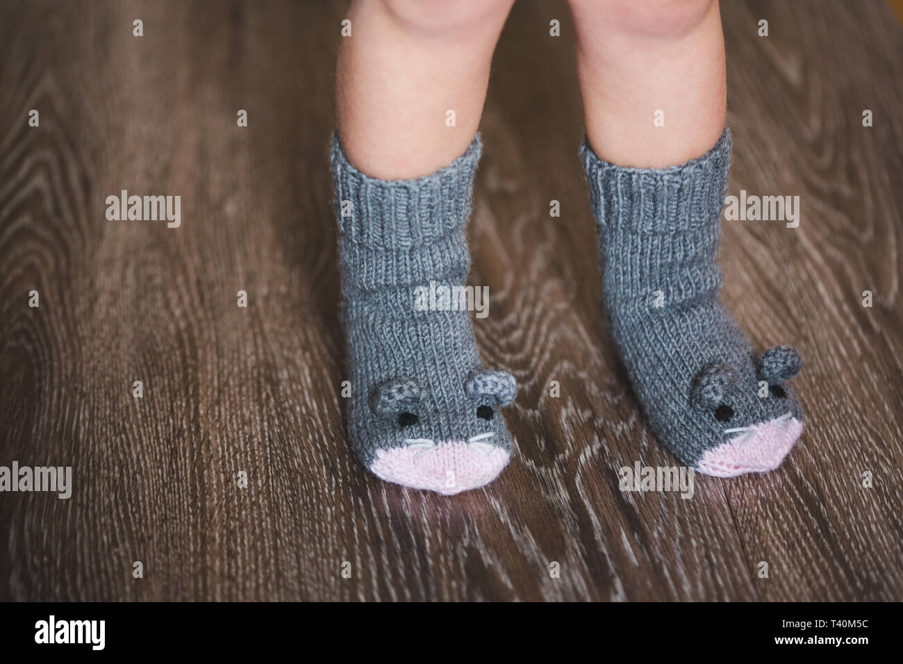 Los pies del bebé en invierno calcetines del ratón sobre fondo de madera  Fotografía de stock - Alamy