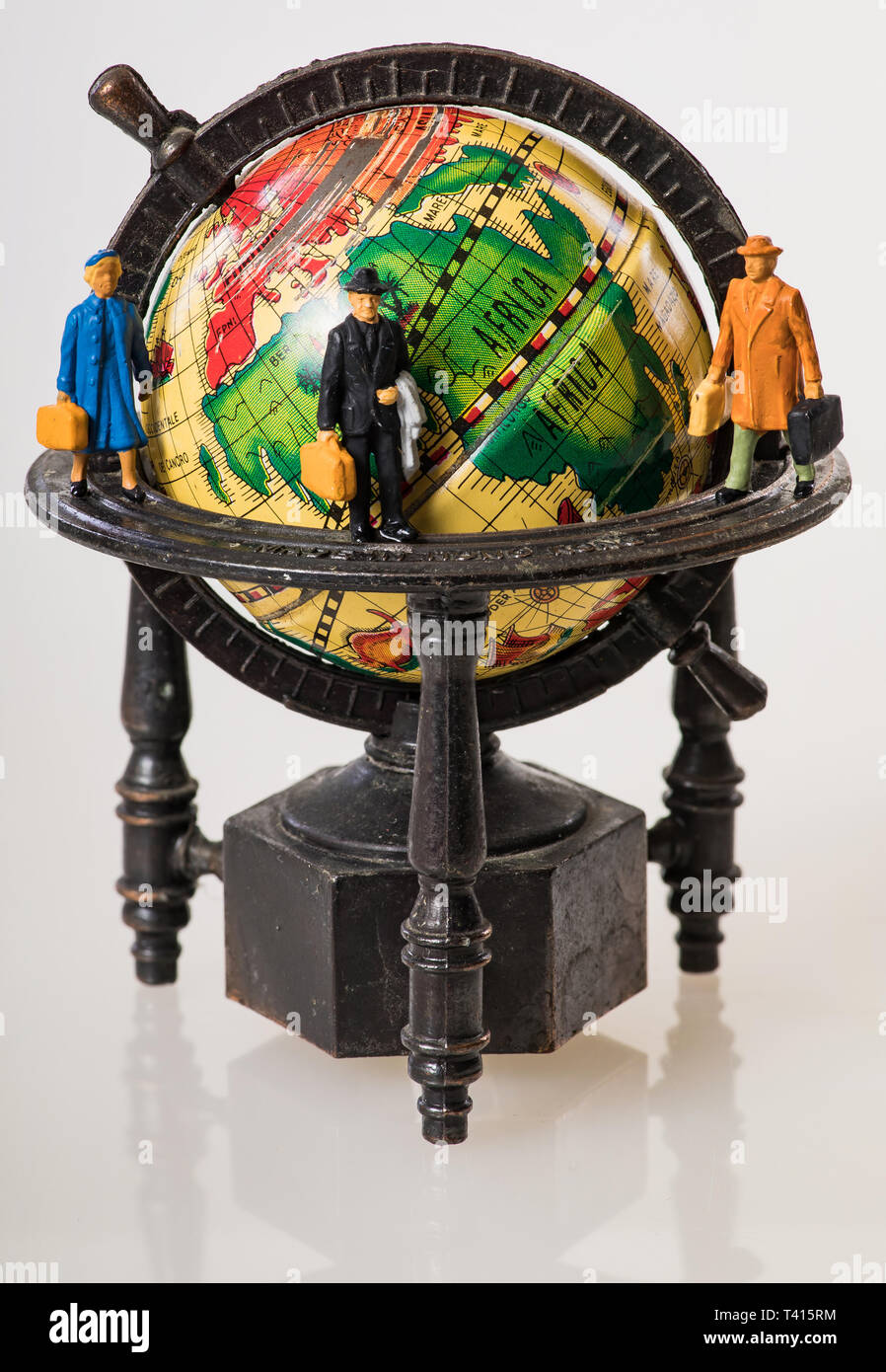 Los viajeros de todo el mundo: figuras en miniatura en un globo Foto de stock