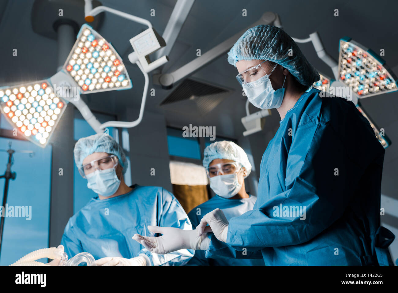 El enfoque selectivo de médicos y enfermeras en uniformes y tapones en quirofano Foto de stock