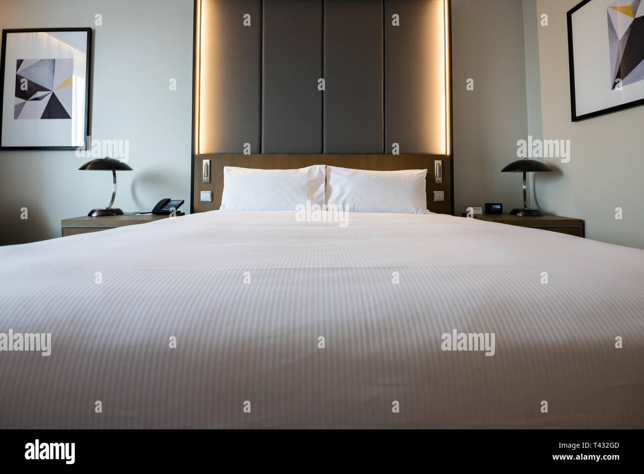 Fotos de una habitación de hotel genérico - Cama, ventana, mesa, lámparas en tiro. Foto de stock