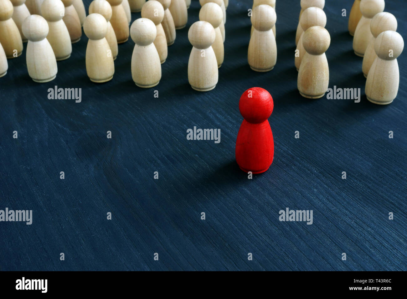 Figurilla roja en la parte delantera de la línea como símbolo de liderazgo. Destaque entre la multitud concepto. Foto de stock