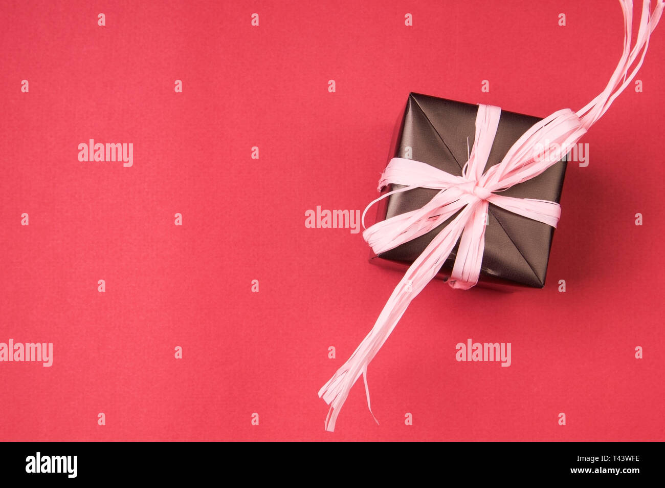 Caja de regalo de color rosa con moños, cintas y sobre un fondo de color  Fotografía de stock - Alamy
