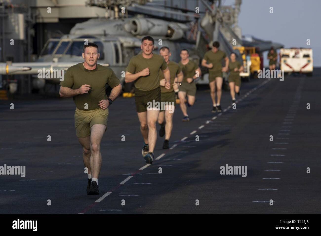 Golfo de Omán (17 de marzo de 2019) - Los Marines de Estados Unidos con la 22ª Unidad Expedicionaria de los Infantes de Marina se ejecutan en la cubierta de vuelo durante un examen de aptitud física a bordo de la clase Wasp buque de asalto anfibio USS Kearsarge (LHD-3). Los marines realizó la prueba antes de comenzar un curso de Instructor de artes marciales para garantizar que puedan satisfacer las exigencias físicas de la formación. Los infantes de marina y marineros con la 22ª MEU y KAARSARGE Amphibious Ready Group están desplegadas actualmente en los EE.UU. 5ª Flota de la zona de operaciones en apoyo de las operaciones navales para garantizar la estabilidad y la seguridad marítima en la región central, la conexión de la Me Foto de stock