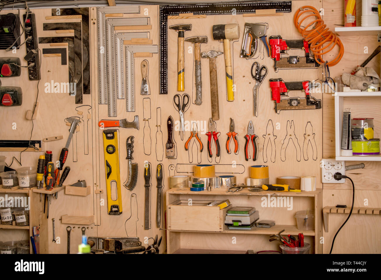 Taller escena. Gran variedad de herramientas de carpintería colgando en el  gran tablero de herramientas. Lápiz contorno trazado para cada herramienta  para ayudar a determinar el lugar Fotografía de stock - Alamy