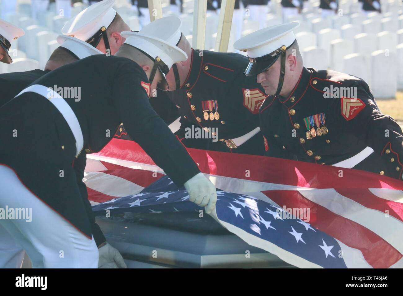 Cuerpo de Infantería de Marina portadores, compañía Bravo marino, cuarteles de Washington D.C., preparar para plegar la bandera nacional durante un funeral todos los honores por el Teniente General Leo Dulacki en el Cementerio Nacional de Arlington, Arlington, Virginia, 13 de marzo de 2019. Dulacki alistado en la Infantería de Marina en 1941 y recibió su comisión como segundo teniente en el 2 de septiembre de 1941. Durante sus 32 años de servicio, Dulacki lucharon en la Segunda Guerra Mundial, Corea y Vietnam; se jubiló en enero de 1974. Sus adornos personales incluyen la Medalla por Servicios Distinguidos con una estrella de oro, la Legión de Mérito con un dispositivo para el distintivo de combate val Foto de stock