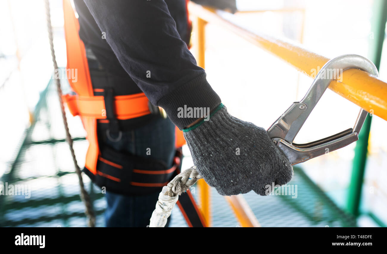 Trabajador de la construcción usando arnés de seguridad y línea de seguridad  que trabajan en la construcción Fotografía de stock - Alamy