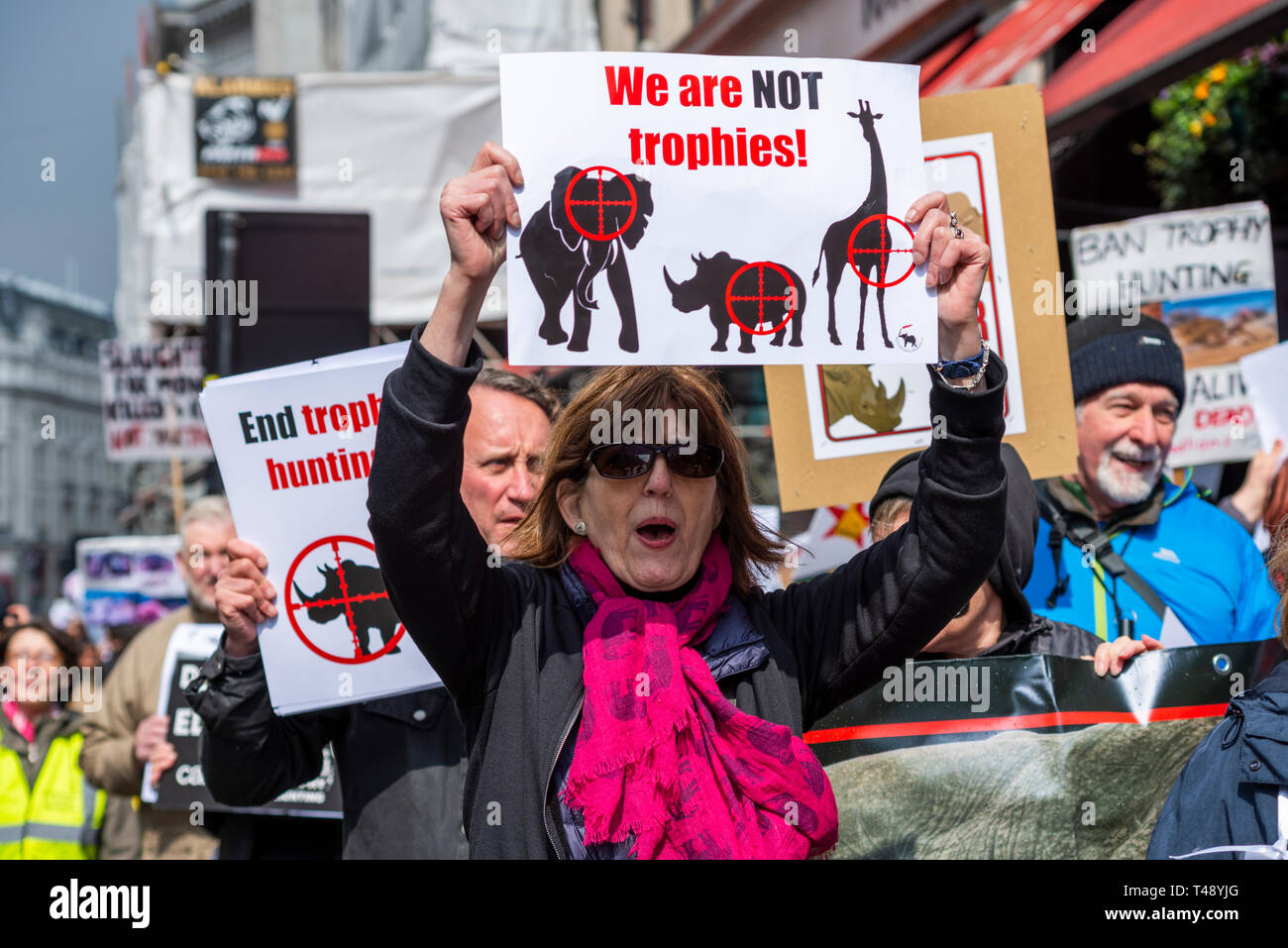 Los manifestantes en una parada la caza de trofeos y la protesta del comercio de marfil, Londres, Reino Unido. Hembra con placard Foto de stock